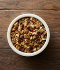 Load image into Gallery viewer, A white bowl filled with chunky, meaty dog food, featuring cubes of beef, visible grains, and vegetables. Placed on a rustic wooden table, conveying a hearty, wholesome feel.