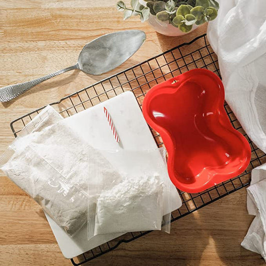Various ingredients for red velvet cake, featuring flour, cocoa, sugar, eggs, buttermilk, and red dye