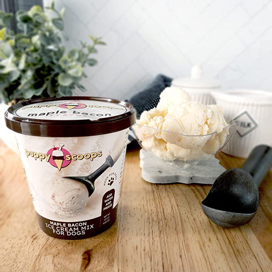 A scoop of ice cream mix sits beside a silver spoon on a white plate.