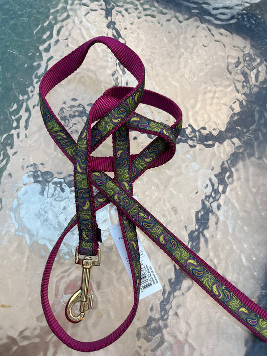 A purple and green Paisley dog leash featuring a stylish gold buckle.
