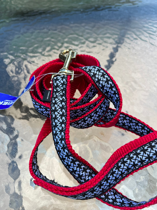 A stylish red and black houndstooth dog leash with a blue identification tag